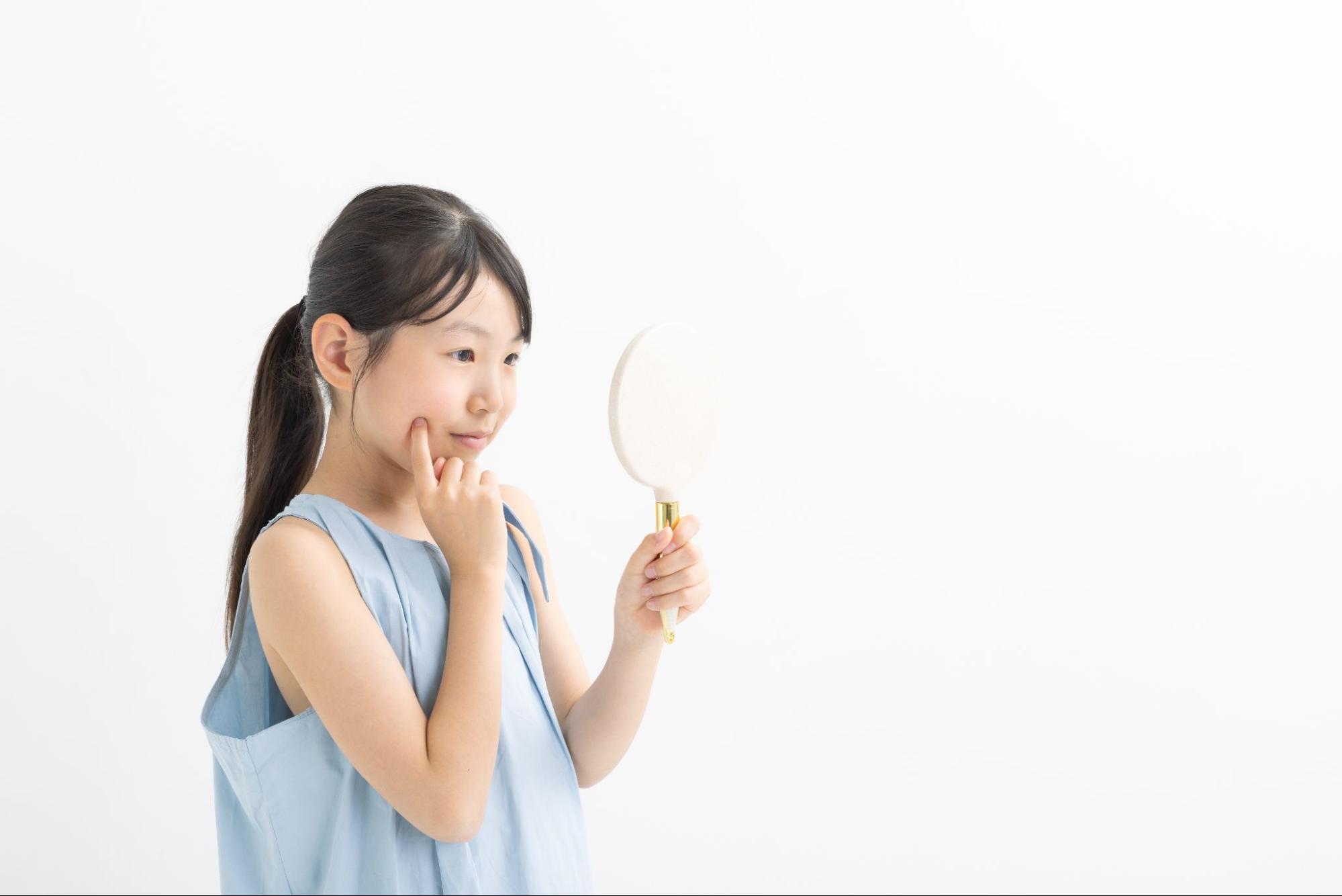 頬を気にする小学生