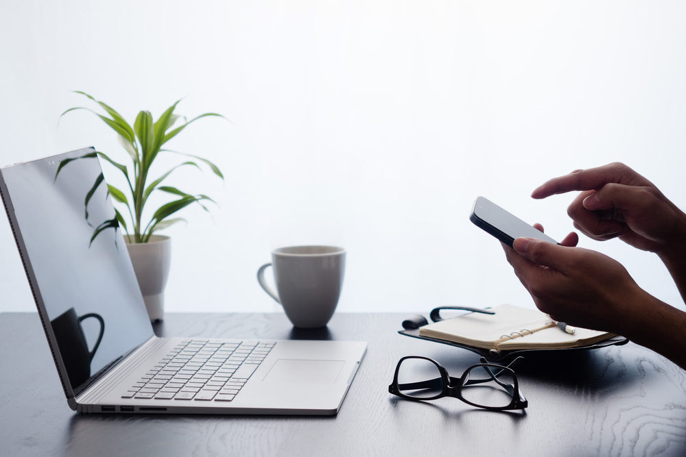 パソコンをみながらスマホを操作する人