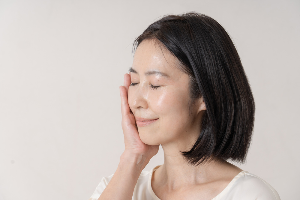 顔に手を添える女性