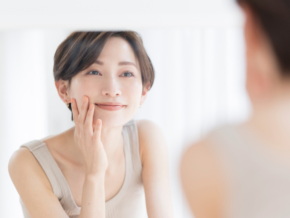 鏡を見て微笑む女性