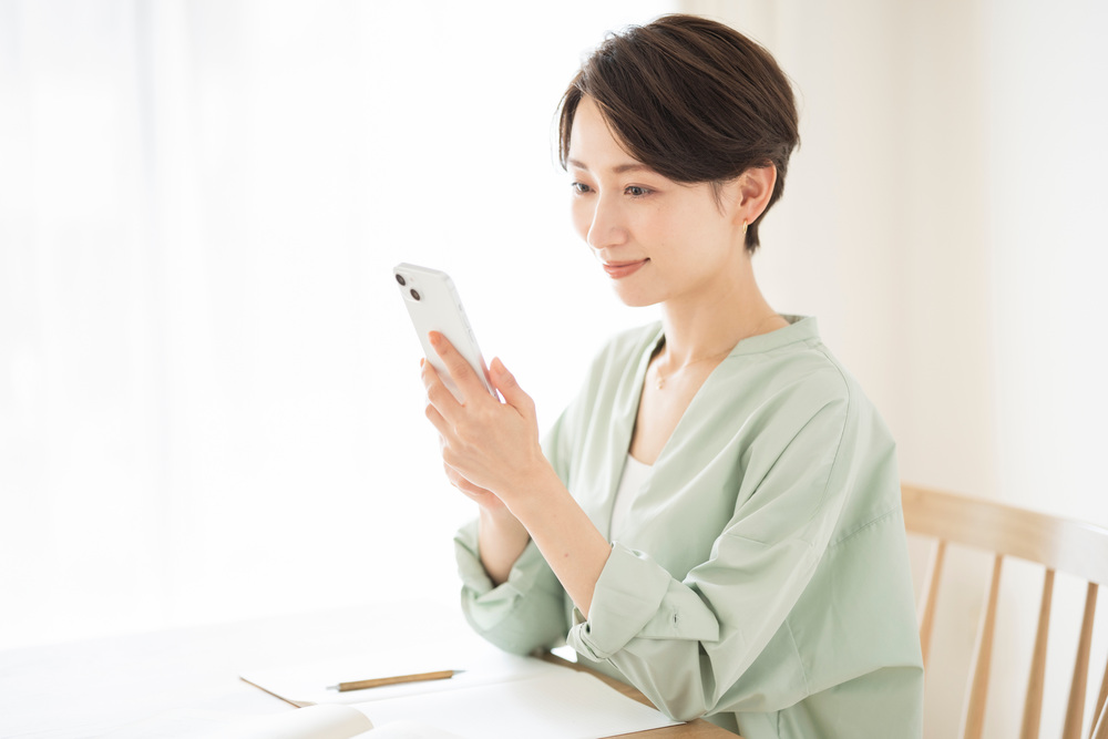 30代女性がスマホを操作している画像