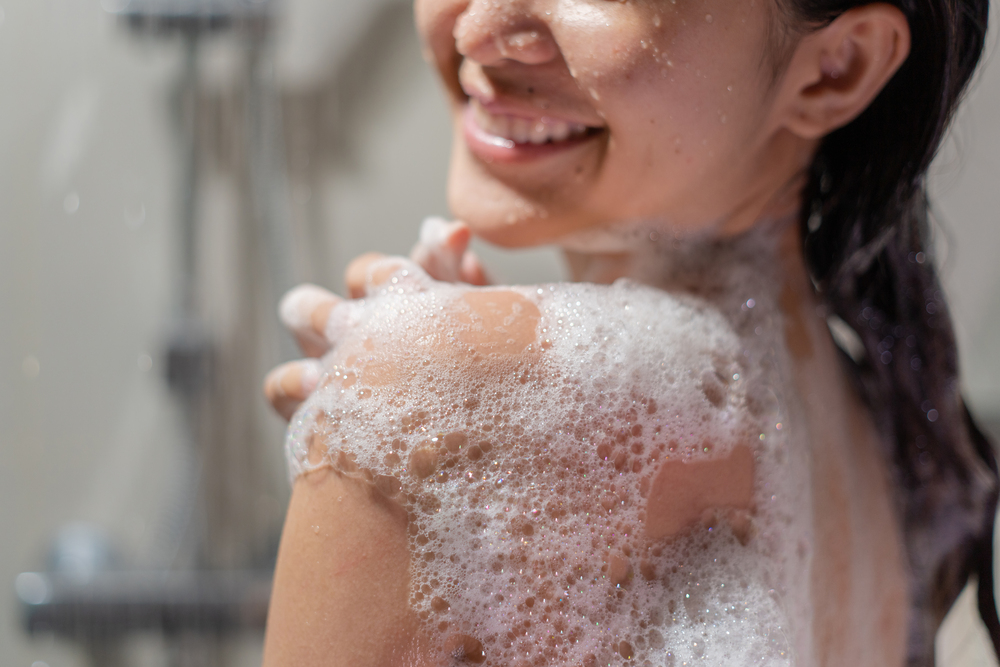 お風呂で体を洗っている女性
