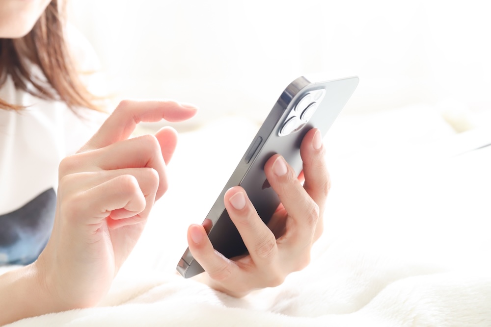 スマホを操作する女性の手元