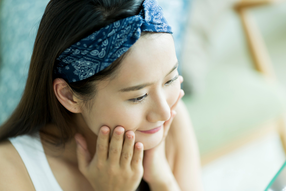 鏡を見て微笑む女性