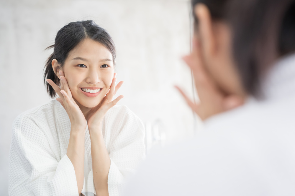 鏡を見て微笑む女性