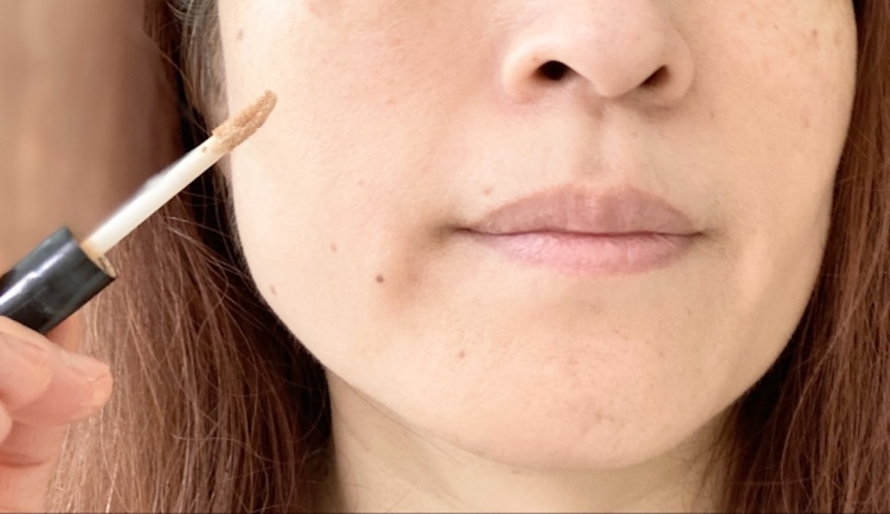 コンシーラーを塗る女性