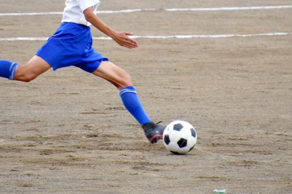 サッカー中の男子学生