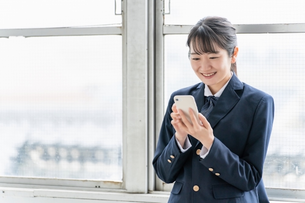 スマホを持つ学生（女性）