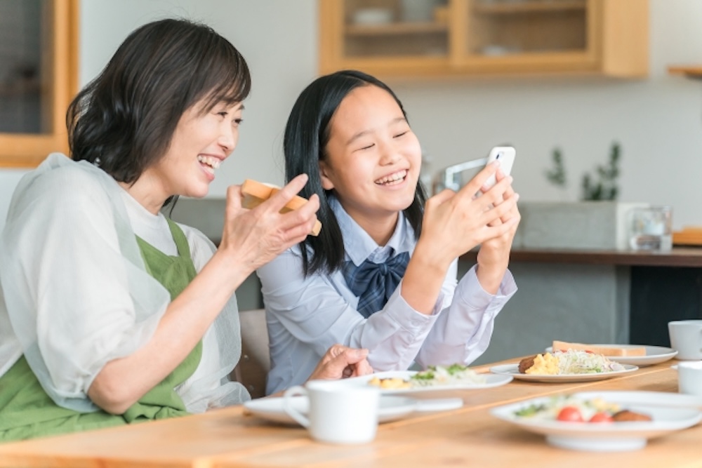 スマホを見て微笑む親子