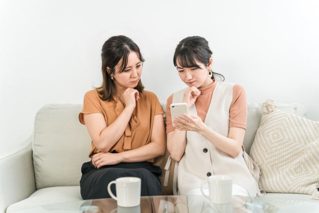 スマホを見て悩む女性たち