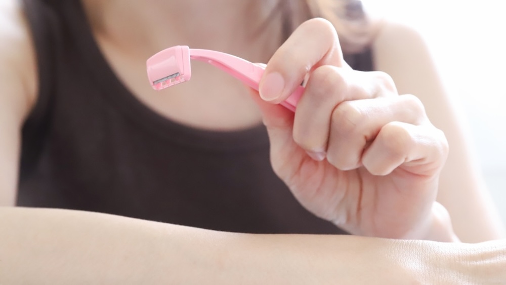 腕のシェービング中の女性